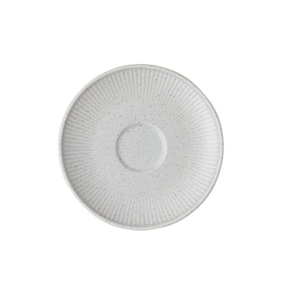 White ceramic saucer with textured design on a white background